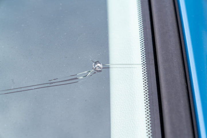 A chipped car windscreen being repaired with the focus on whether windscreen repairs are covered by insurance.